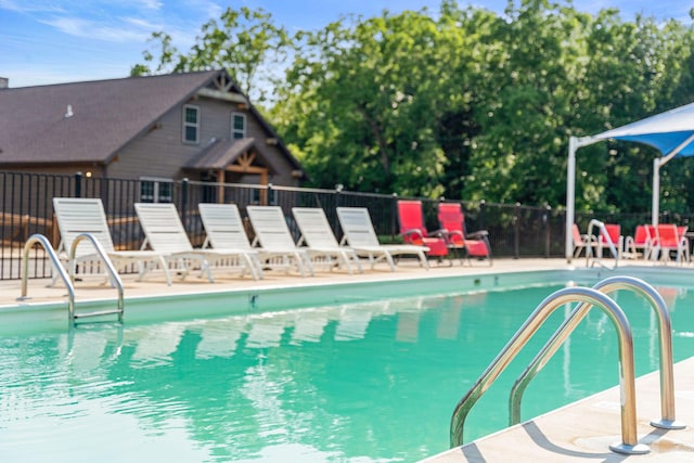 community pool with fence and a patio area