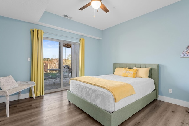 bedroom featuring wood finished floors, access to exterior, baseboards, visible vents, and a ceiling fan