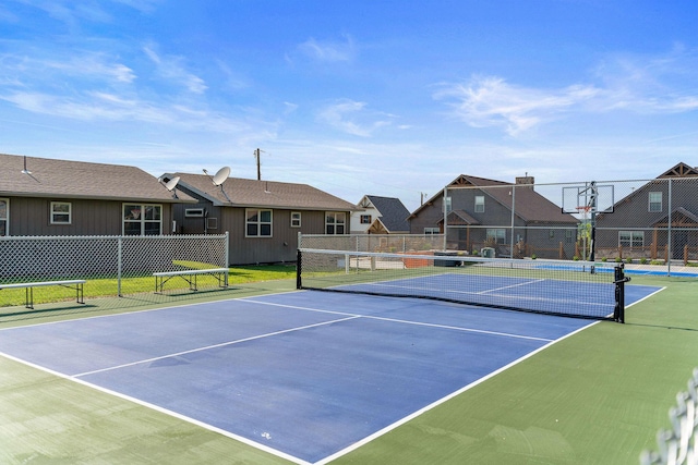 view of sport court with a residential view, community basketball court, and fence