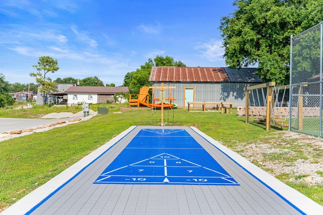 view of home's community featuring a lawn, shuffleboard, and fence
