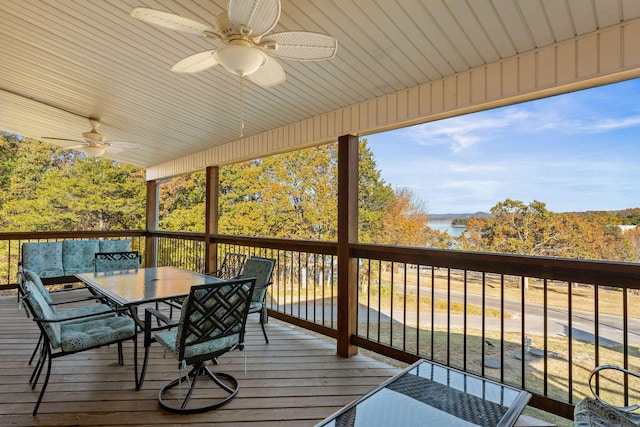 wooden deck featuring outdoor dining space, ceiling fan, and a water view