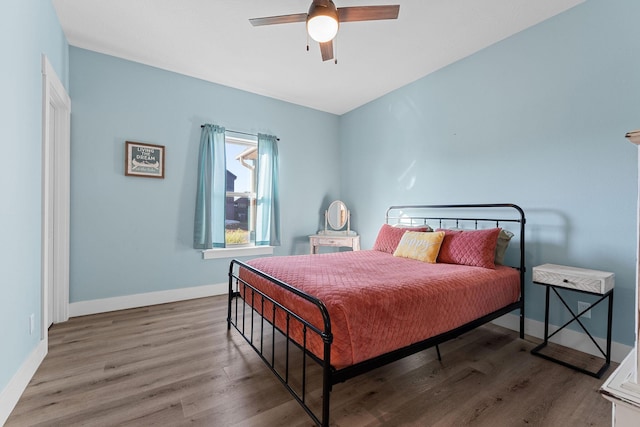 bedroom with baseboards, wood finished floors, and a ceiling fan
