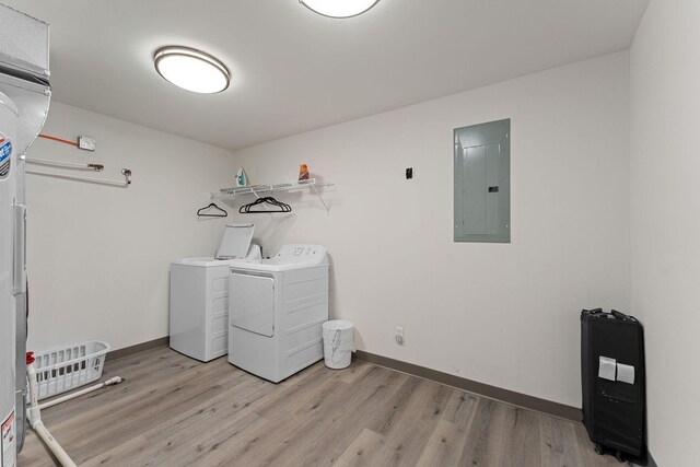 laundry room with light hardwood / wood-style flooring, washer and dryer, and electric panel