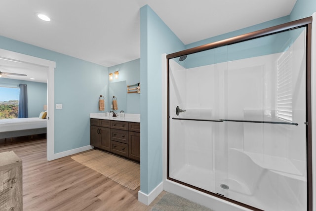 bathroom with vanity, walk in shower, hardwood / wood-style flooring, and ceiling fan