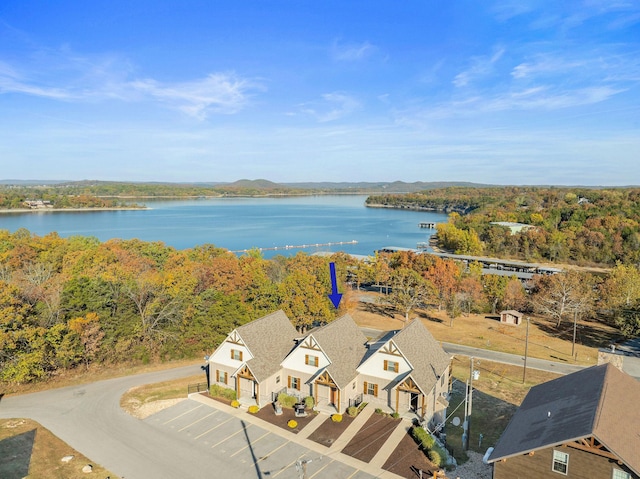 birds eye view of property featuring a forest view and a water view