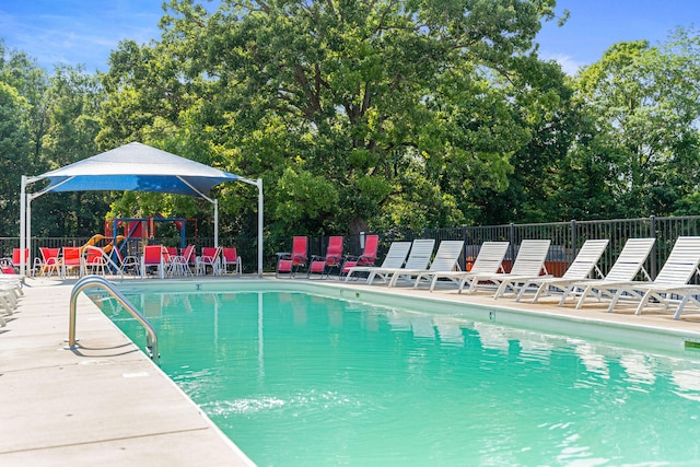 view of swimming pool featuring a playground