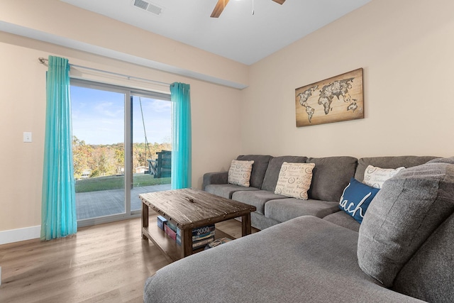 living area featuring baseboards, visible vents, wood finished floors, and ceiling fan