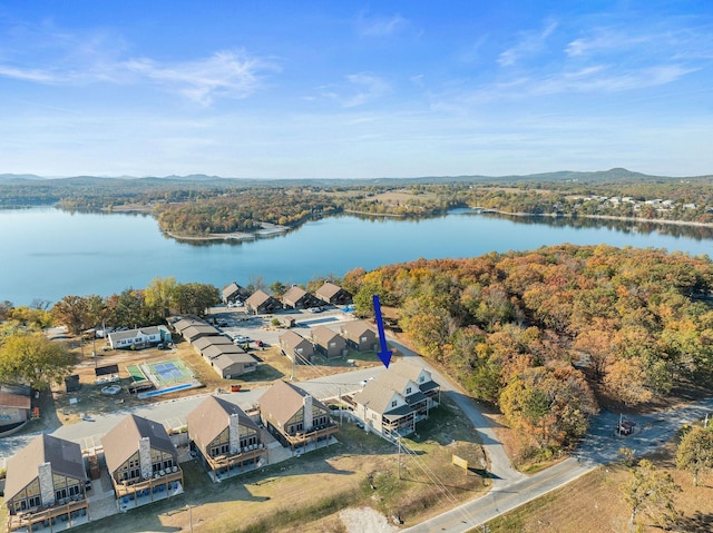 drone / aerial view featuring a residential view, a water view, and a wooded view