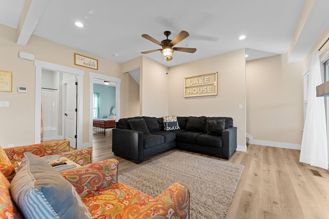 living room with beamed ceiling, light hardwood / wood-style flooring, and ceiling fan