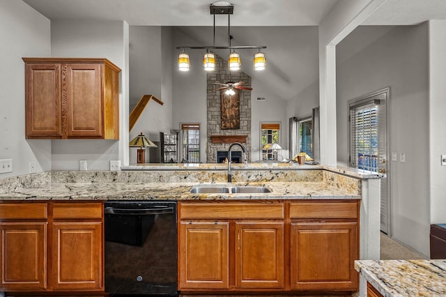 kitchen with sink, decorative light fixtures, a stone fireplace, lofted ceiling, and dishwasher