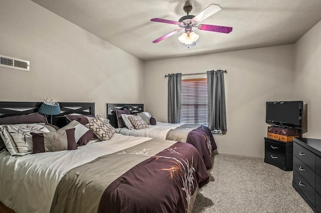 bedroom featuring a textured ceiling, light carpet, and ceiling fan