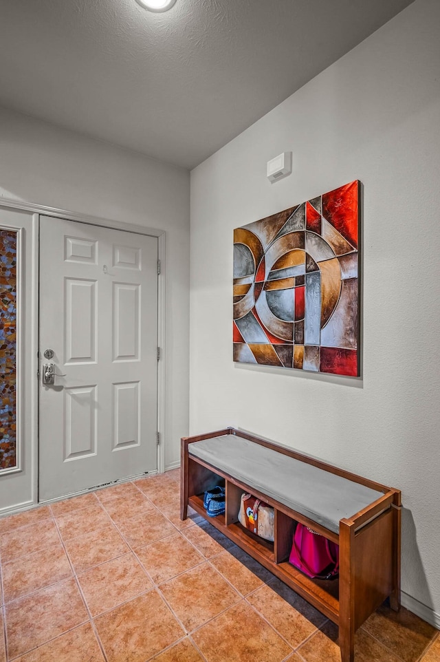 tiled entryway featuring a textured ceiling