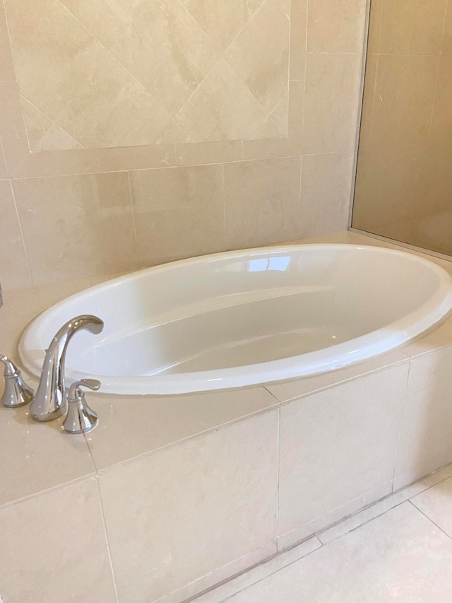 bathroom featuring tile patterned floors and tiled tub