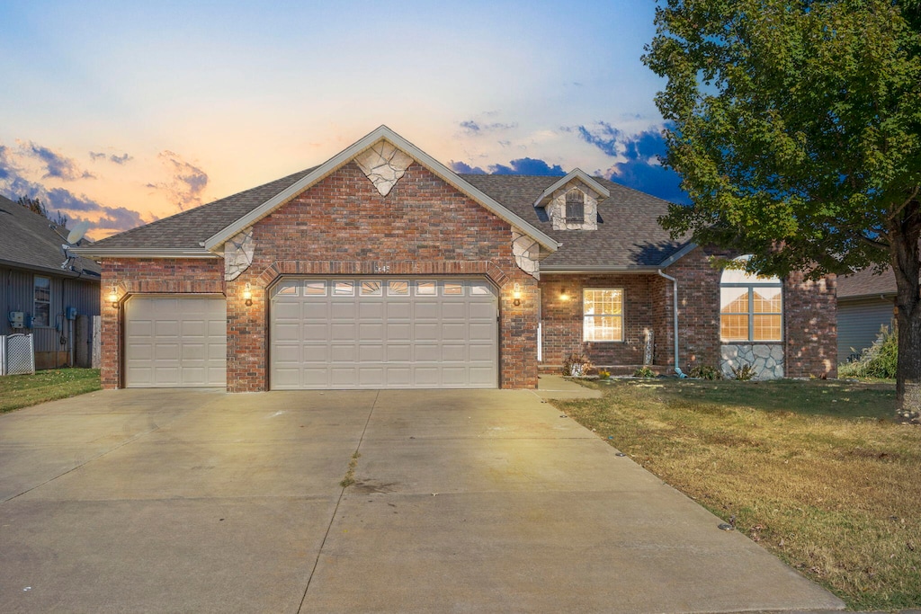 view of front of property featuring a yard and a garage