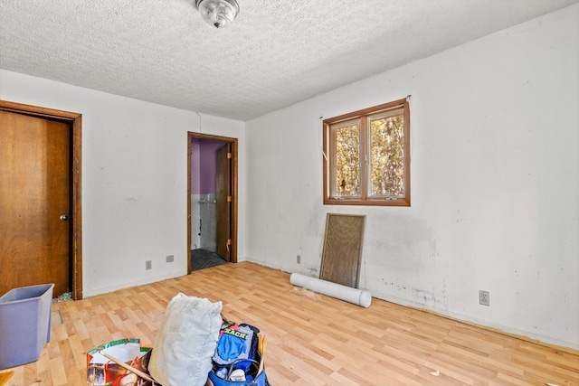 unfurnished bedroom featuring a textured ceiling and wood finished floors