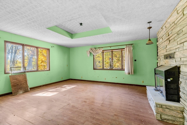 unfurnished living room with hardwood / wood-style flooring and a textured ceiling