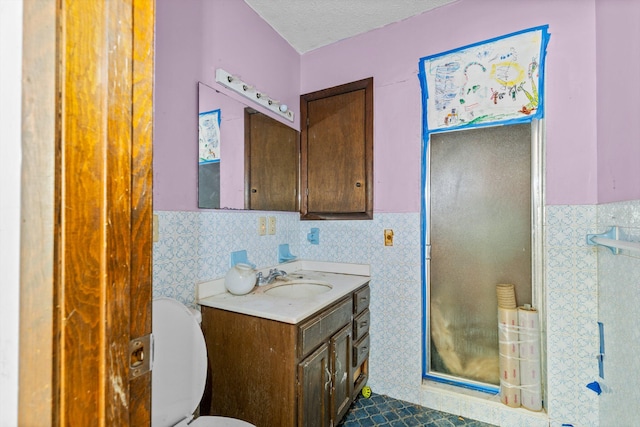 bathroom featuring tile walls, vanity, a textured ceiling, and toilet