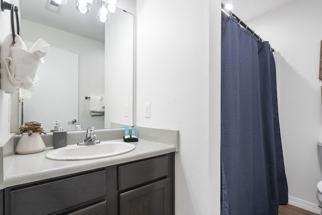 bathroom featuring vanity, walk in shower, toilet, and wood-type flooring