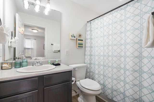 bathroom with vanity, toilet, and walk in shower