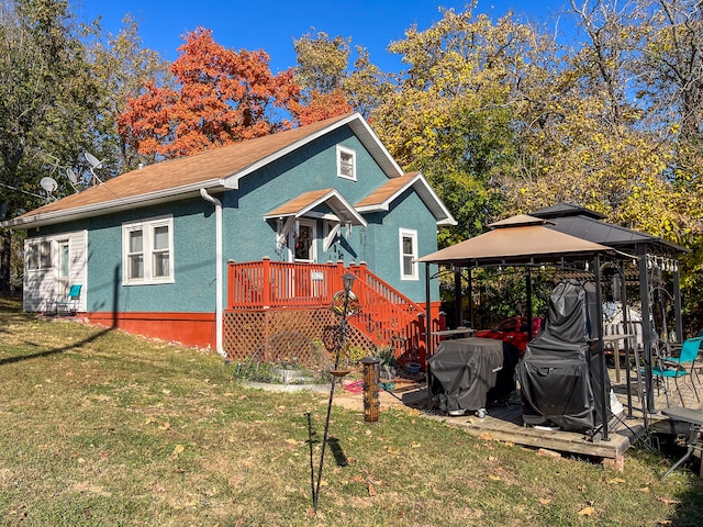 exterior space featuring a gazebo, a front lawn, and a wooden deck