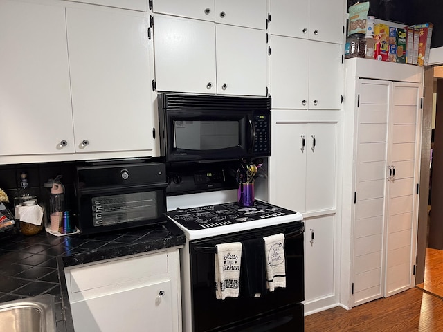 kitchen featuring white cabinets, black appliances, and dark hardwood / wood-style flooring