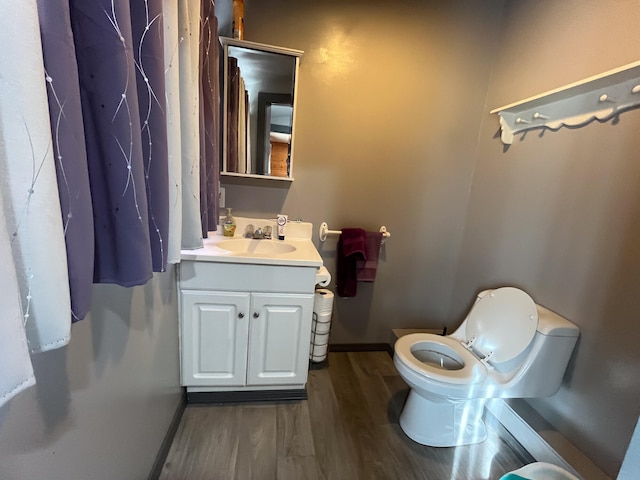 bathroom featuring toilet, hardwood / wood-style flooring, and vanity