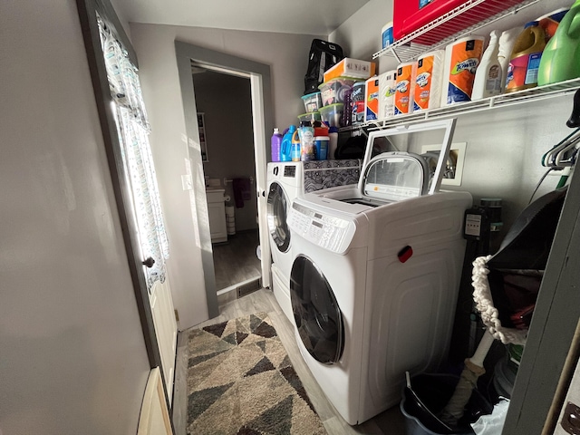 washroom featuring washing machine and dryer and light hardwood / wood-style flooring