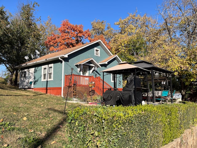 exterior space with a gazebo, a front lawn, and a deck