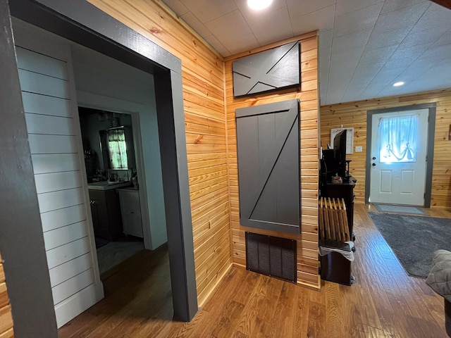 mudroom with wood walls and hardwood / wood-style floors