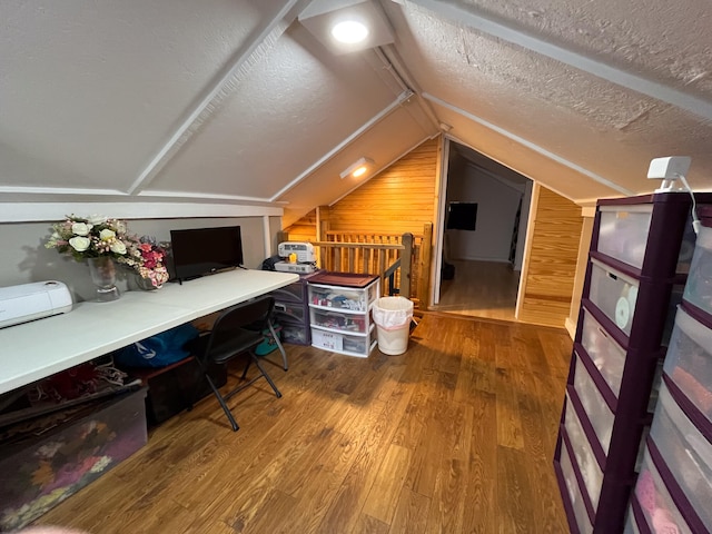 office with a textured ceiling, wood-type flooring, lofted ceiling, and wooden walls