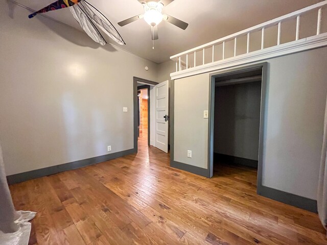 1025 Woodland Ave, West Plains, MO 65775 - unfurnished bedroom with wood finished floors, a closet, baseboards, and a ceiling fan