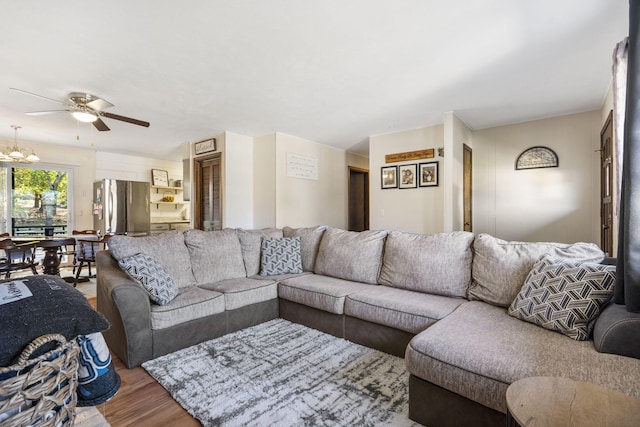 living room featuring hardwood / wood-style floors and ceiling fan with notable chandelier