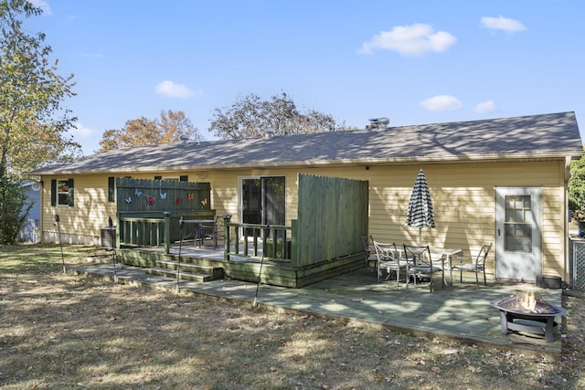 back of house featuring a wooden deck, a patio area, and an outdoor fire pit