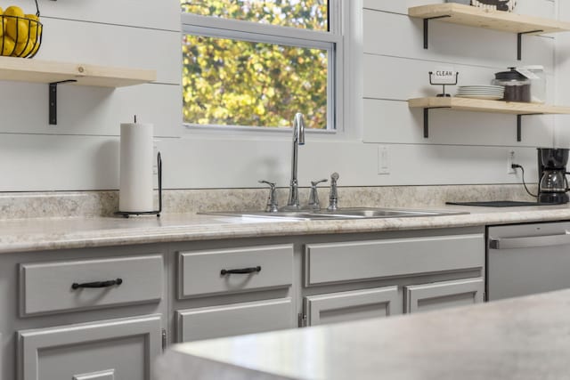 kitchen featuring stainless steel dishwasher, sink, and white cabinets