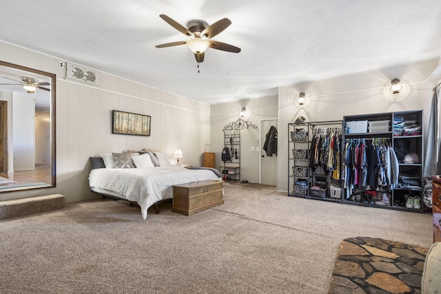 bedroom featuring ceiling fan, wood walls, and carpet flooring