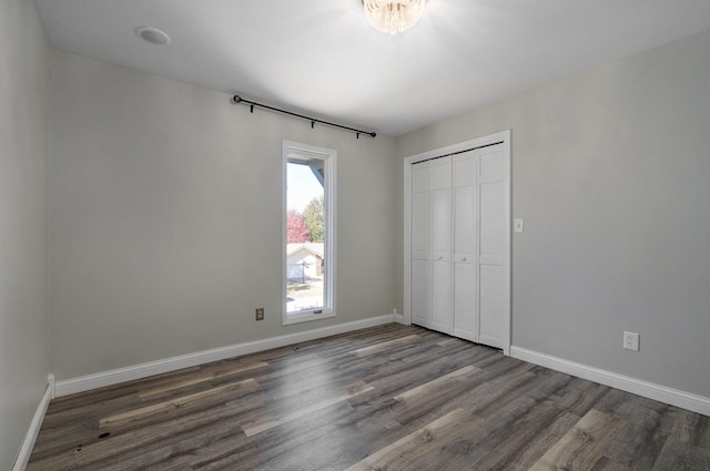 unfurnished bedroom featuring a closet and dark wood-type flooring