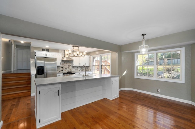 kitchen featuring white cabinets, hanging light fixtures, dark hardwood / wood-style floors, tasteful backsplash, and stainless steel appliances