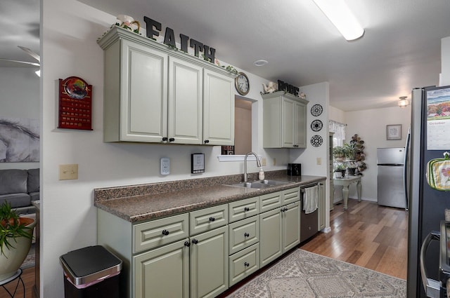 kitchen featuring appliances with stainless steel finishes, light wood-type flooring, ceiling fan, and sink