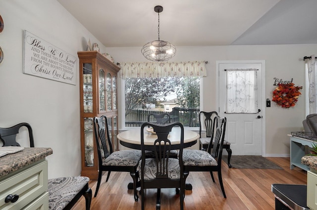 dining area with a notable chandelier and light hardwood / wood-style flooring