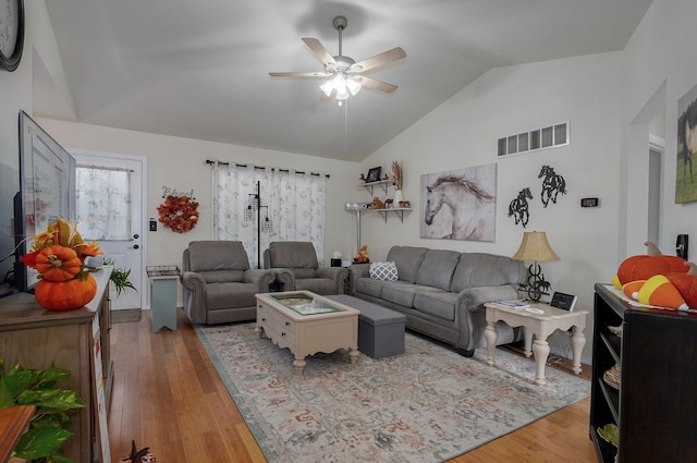 living room with ceiling fan, lofted ceiling, and hardwood / wood-style flooring