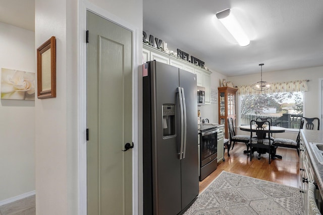 397 Micahs Xing, Reeds Spring, MO 65737 - kitchen featuring stainless steel appliances, white cabinets, pendant lighting, light wood finished floors, and light countertops