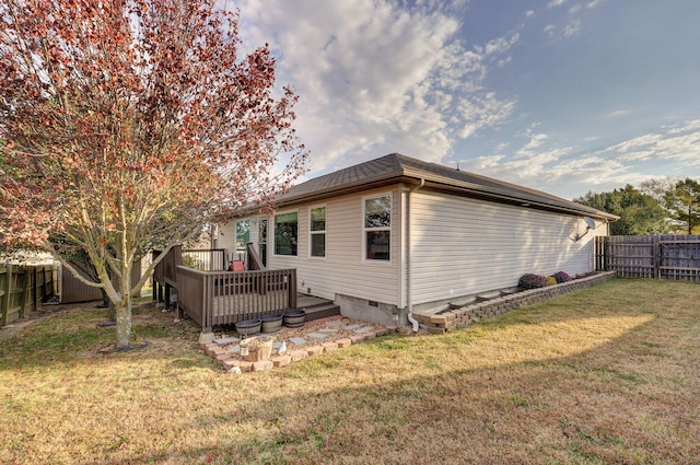 view of side of home featuring a deck and a yard