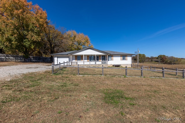 view of front of house with a front lawn, a garage, and a rural view