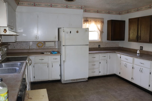 kitchen featuring exhaust hood, sink, white cabinets, white fridge, and a textured ceiling