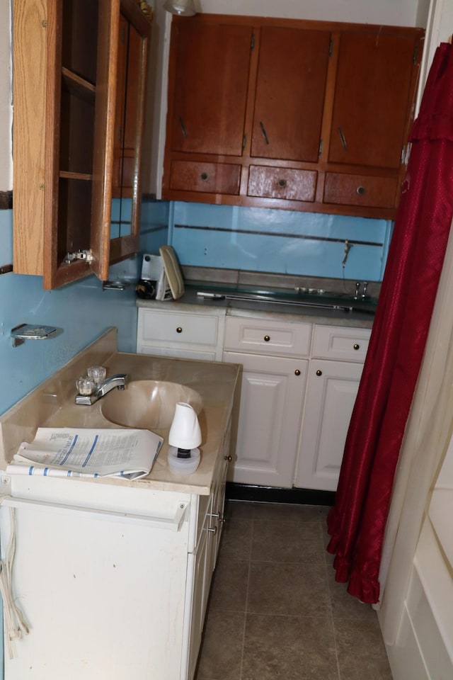 kitchen featuring white cabinetry, sink, and dark tile patterned flooring