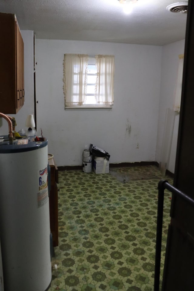 interior space with gas water heater and a textured ceiling