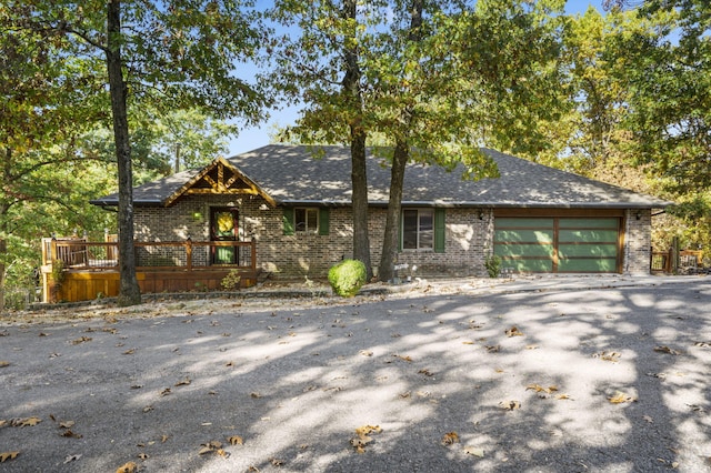 55 Lovers Ln, Branson West, MO 65737 - view of front of house featuring a deck, aphalt driveway, brick siding, and a garage