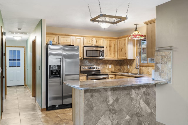 kitchen with appliances with stainless steel finishes, hanging light fixtures, decorative backsplash, sink, and kitchen peninsula