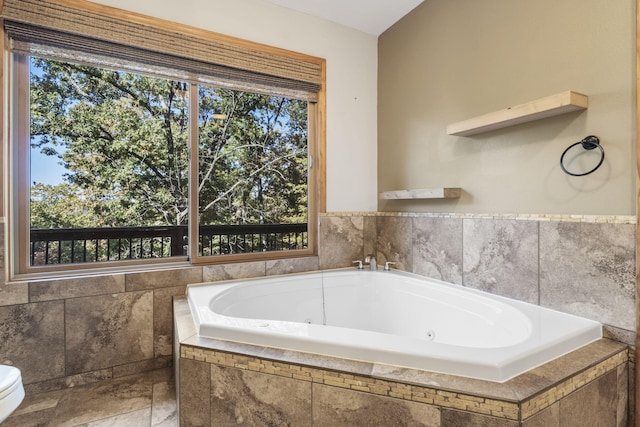 bathroom featuring plenty of natural light and tiled tub