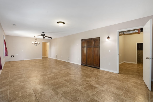 spare room featuring ceiling fan with notable chandelier